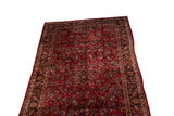 Angled view of a vintage American Sarouk carpet's cherry red field and intricate floral bouquets.