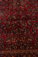 Dense floral bouquets on the plush cherry red pile of a vintage American Sarouk carpet.