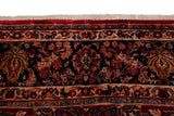 Plush pile and intact ivory fringe on a vintage Sarouk carpet's intricate floral border.
