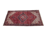 Vintage Persian Mehrivan carpet with a classic Heriz style stepped medallion in cherry red, navy blue, and ivory.