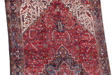 Geometric stepped medallion with interconnected vinery in red, navy, and ivory on a vintage Persian carpet.