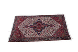Vintage Persian Mehrivan carpet with a geometric stepped medallion in cherry red, navy blue, and ivory.