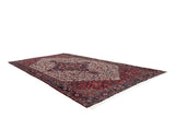 Angled view of an oversize Mehrivan carpet with a traditional red and navy stepped medallion.