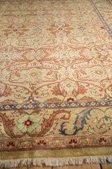 Low-angle view highlighting the high luster wool pile and scrolling border of the vintage rug.