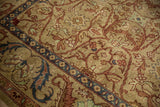 Angled view of the carpet's lustrous, full wool pile and scrolling leaf and palmette border.
