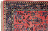 Ornate navy border with boteh design and delicate fringe on ruby red Mohajeran Sarouk rug.