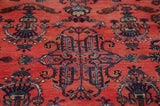 Ornate navy blue floral vases and fluid vinery on ruby red Mohajeran Sarouk field.