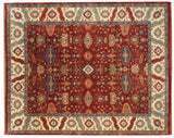 A vintage Indian carpet in a Heriz design with geometric floral motifs in cherry red, blue, and ivory.