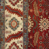 Geometric floral gul and serrated leaf motifs on the border of a vintage Heriz design carpet.