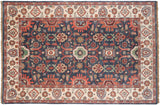 Detail of a vintage Indian Sultanabad rug with dusty navy, blush, and celadon floral arabesques.