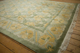 Embossed carved contour relief with saffron yellow floral cross-section on vintage Indian carpet.