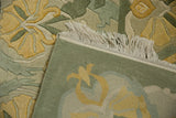 Vintage Indian carpet showing plush carved yellow floral pile, woven green back, and fringe.