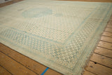 Angled perspective of a distressed Tabriz rug highlighting its evenly worn pile and floral border.