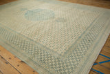 Angled view of a vintage Tabriz design carpet showing its uninterrupted lattice pattern and faded medallion.