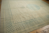 Angled view of the sea foam green floral border and ivory lattice field on a distressed carpet.