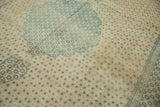 Even wear across the knot heads on a distressed vintage rug with a blue floral lattice pattern.