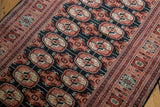 Angled view of the fine Bokhara rug runner's detailed gul medallions and intricate border.