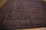 Intricate geometric borders in red and navy on the plush wool pile of a vintage Bokhara carpet.