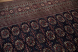 Fine geometric border and plush navy field of a vintage hand-knotted Bokhara carpet.