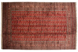 Repeating 'elephant footprint' gul medallions in columns on a vintage cherry red Bokhara carpet.