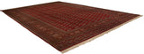Angled perspective of a vintage Bokhara carpet showcasing the high sheen on its cherry red wool pile.