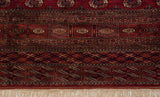 Hand-knotted geometric borders in cherry red and navy terminating in clean, dense ivory fringe.