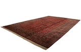 Angled view of a fine Bokhara carpet, its lustrous wool pile showing a repeating gul pattern.