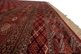 A low angle view of a vintage Bokhara carpet highlighting its lustrous wool pile and repeating geometric guls.