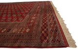 Angled corner view of a fine Bokhara carpet highlighting its intricate geometric borders and ivory fringe.
