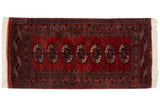 Vintage Bokhara rug with rich red repeating gul medallions, navy, ivory, and plush sheen. 2'4