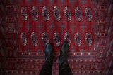 Overhead view showing the plush red pile and detailed gul medallions of a fine Bokhara rug.