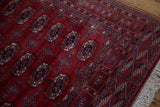 Lustrous red pile and intricate geometric border on a vintage Bokhara rug with clean ivory fringe.