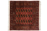 Vintage Bokhara square rug with a repeating gul medallion pattern in dusty rose, navy, and brown.