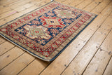 Concentric triple medallion design in indigo, cherry red, and ivory on a Pakistani Caucasian rug.