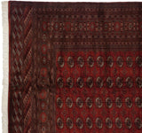 Vintage Bokhara carpet corner showing intact side selvage, intricate borders, and plush red pile.