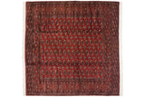 A vintage Bokhara square carpet featuring repeating gul medallions over a cherry red field.
