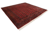 Angled view of a fine Bokhara square carpet highlighting the lustrous sheen on its red wool pile.