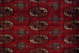 A tight and fine weave showing repeating gul medallions in cherry red, navy, and ivory.