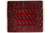 Vintage Bokhara square rug with gul medallions in navy and ivory on a cherry red field.