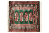 A vintage fine Bokhara rug mat with rust-colored gul medallions on a mallard green field and geometric borders.