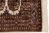 Close-up of the fine Bokhara rug corner showing the geometric border and original ivory fringe.