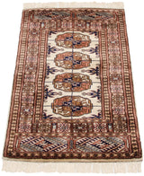 Fine Pakistani Bokhara rug mat viewed from an angle, showcasing the high sheen of its plush wool pile.