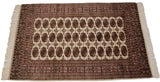 Perspective view of a vintage Bokhara rug, highlighting its detailed gul medallions and complex borders.