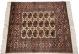 Plush, finely woven Bokhara rug featuring detailed gul medallions in camel, navy, and copper tones.