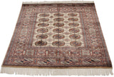 Vintage Bokhara rug corner featuring intricate camel, navy geometric borders and elephant footprint motifs.