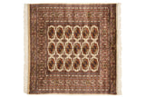 Symmetrical grid of gul medallions in navy, gold, and blush on an ivory field.