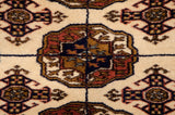 Close-up of a geometric gul medallion showing the plush, fine weave of a vintage Bokhara rug.