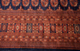 Intricate geometric borders and navy, chestnut gul medallions on a vintage Bokhara carpet.