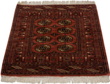 Vintage Bokhara rug featuring repeating gul medallions in dusty rose, navy, and ivory tones.