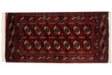 Vintage Bokhara rug with repeating gul medallions in wine red, navy blue, and ivory on a burgundy field.